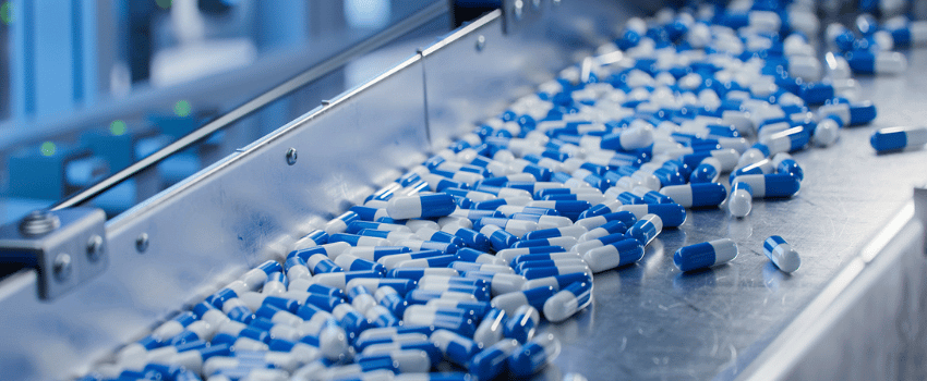 Blue Capsules on Conveyor at Modern Pharmaceutical Factory